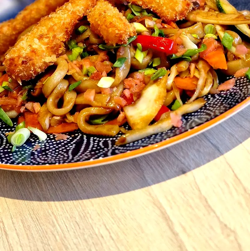Smażony udon z krewetkami w panko na granatowym talerzu